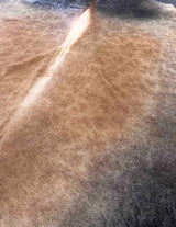 Close-up of cowhide rug with a focus on texture and color gradient.