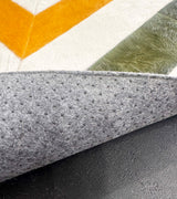 Underside of the stitched cowhide rug showing gray felt backing with nonslip grip dots