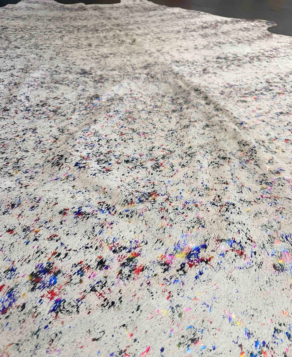 Close-up of a speckled cowhide with multicolored flecks on a white background