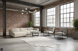Modern living room with white furniture, large windows, cowhide rug, and brick walls.