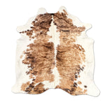 Brown and white cowhide rug on a white background