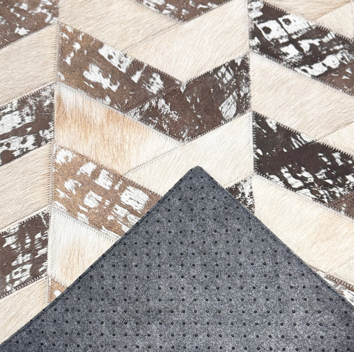 Palermo stitched cowhide sample with a corner turned back to show gray felt backing and small black rubber grip dots.