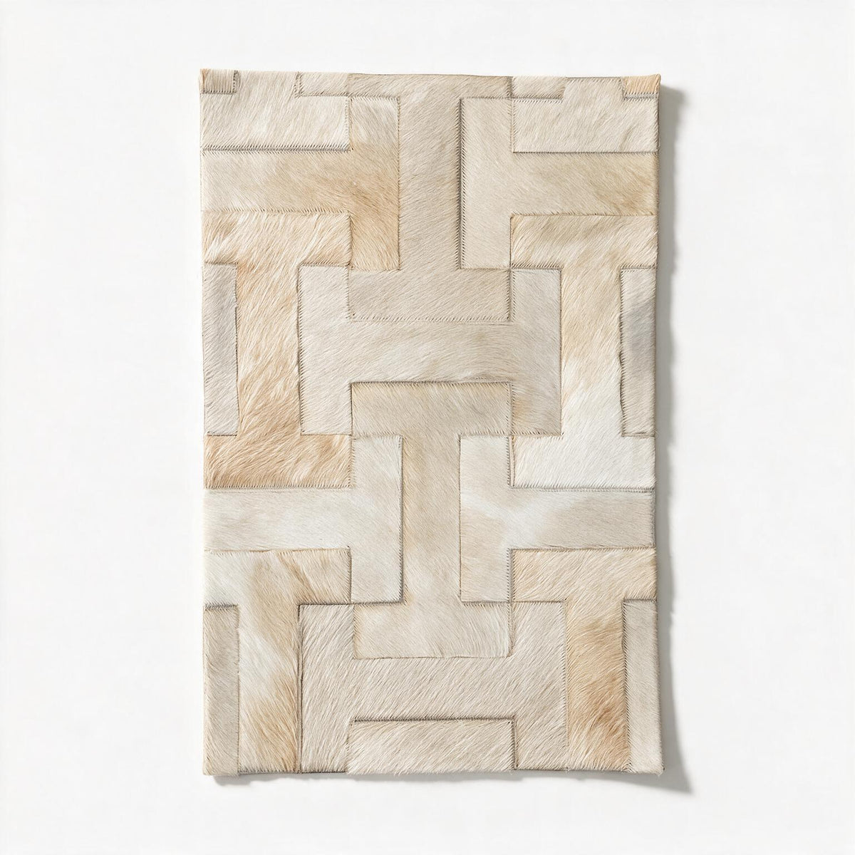 Enchanté cowhide rug sample showing the ivory and pale beige interlocking I-shaped pattern