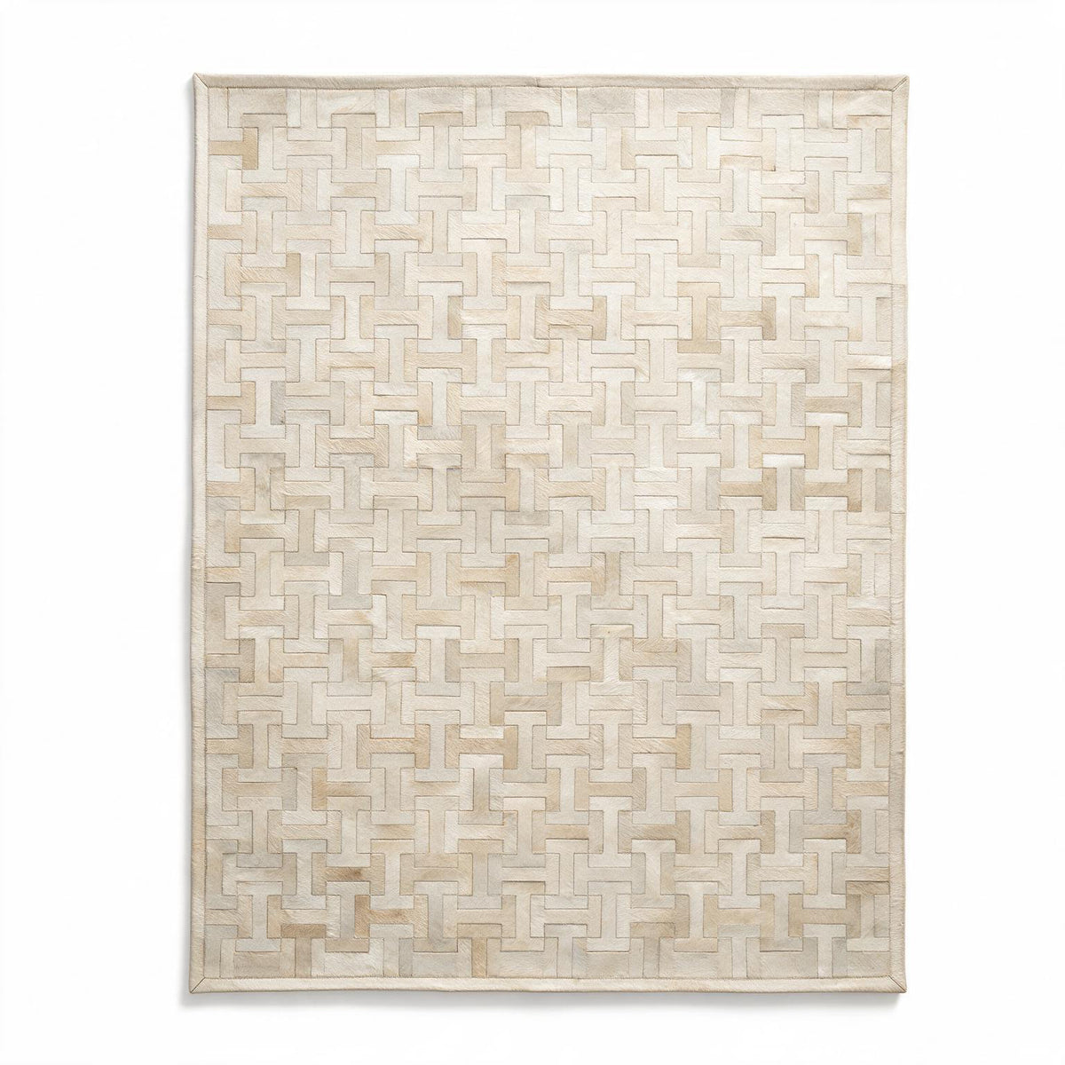 Enchanté custom stitched cowhide rug in ivory and cream with a repeating interlocking I-and-H geometric pattern