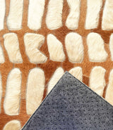 Paros stitched cowhide rug sample showing protective felt backing with discreet rubber grip dots