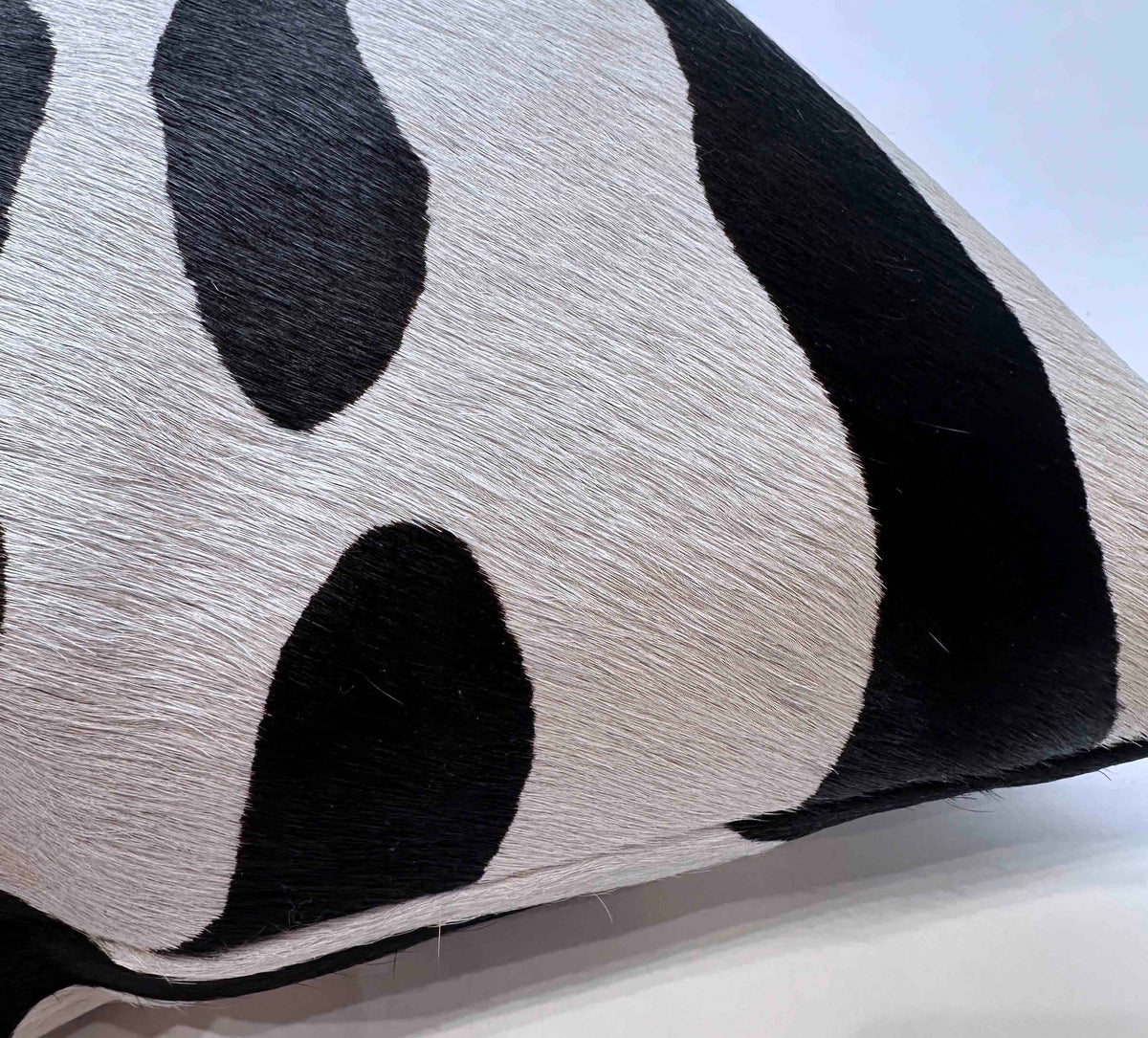 Close-up of stenciled zebra cowhide pillow showing genuine hair-on-hide texture