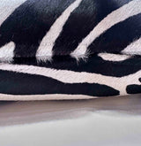 Stenciled zebra cowhide pillow detail showing hidden zipper and black ivory pattern