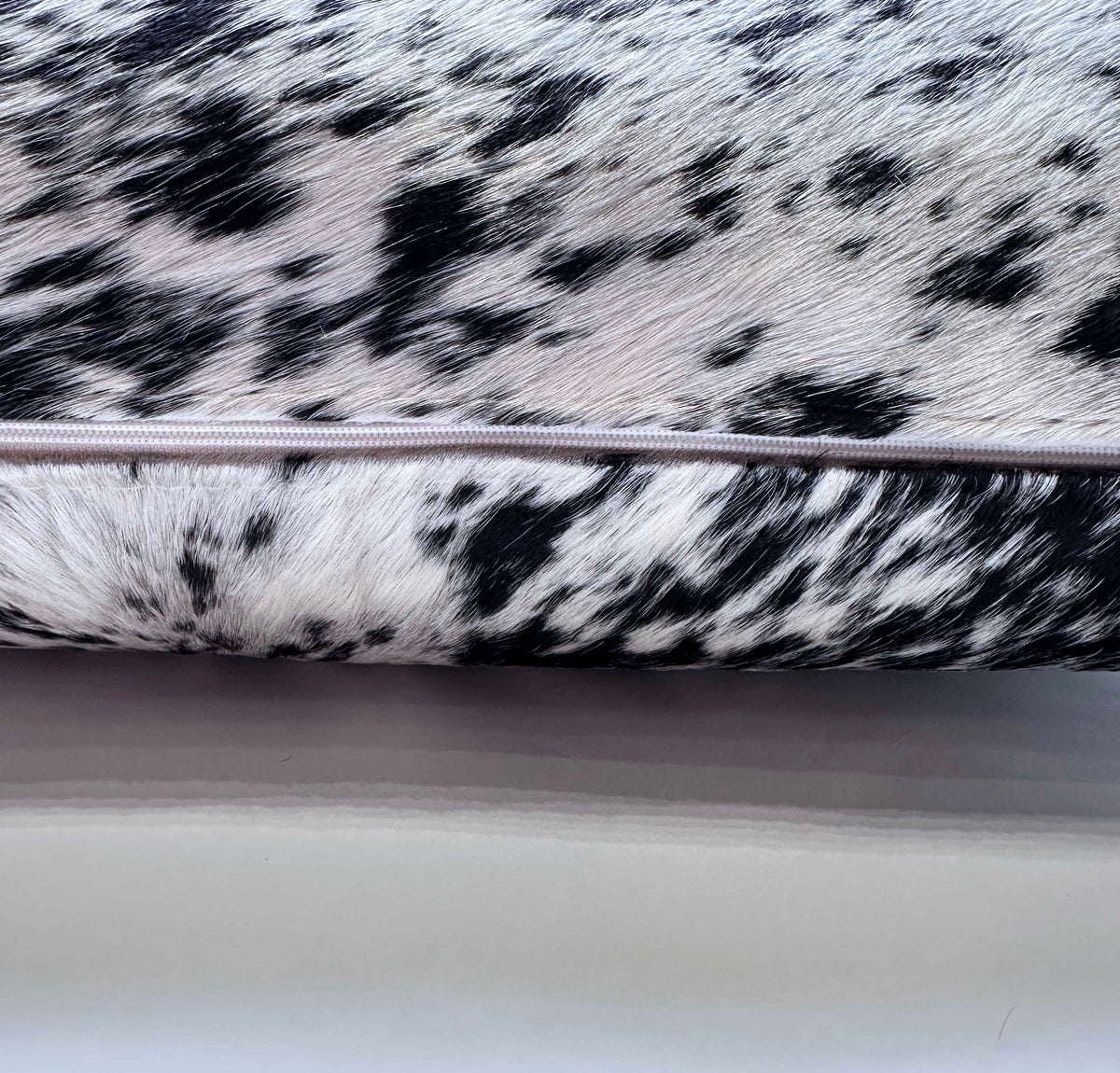 Natural salt and pepper cowhide pillow detail with hidden zipper closure