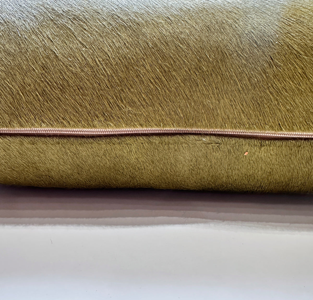 Moss green cowhide pillow detail with hidden zipper closure
