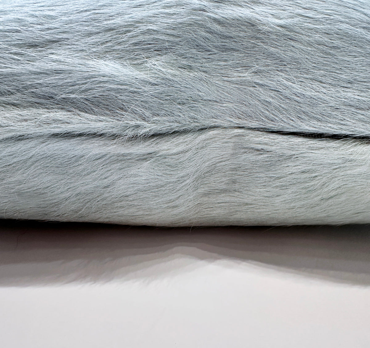Close-up of Sea Glass blue cowhide pillow zipper showing natural hair-on-hide texture