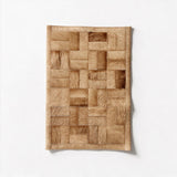 Tessaro 16-by-24-inch stitched cowhide rug sample in warm camel and caramel with a geometric basket-weave pattern