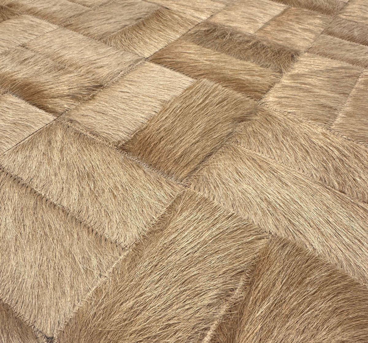 Close-up of Tessaro rectangular cowhide pieces with varied hair direction and coordinating zigzag stitching
