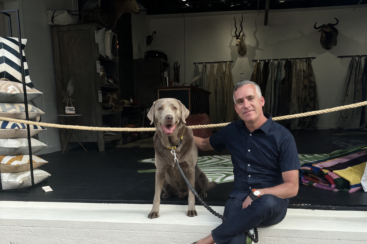 Furug founder with his dog in the Furug showroom surrounded by hides and home decor.