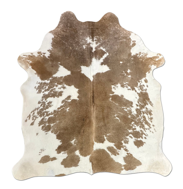Brown and white cowhide rug on a white background