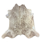 Cowhide rug with a mix of brown and gray patches on a white background