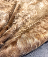 Close-up of brown cowhide fur texture on a textured surface