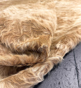 Close-up of a beige cowhide fur rug on a wooden floor