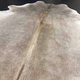 Close-up of a cowhide rug with a visible seam and texture