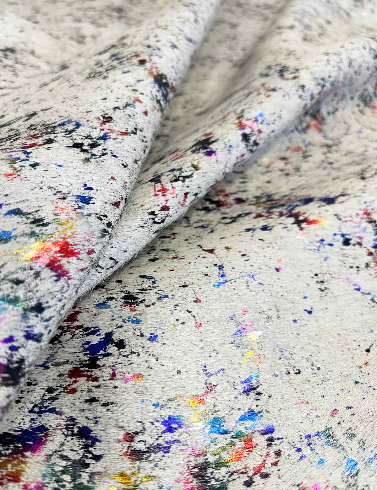 Close-up of cowhide with multicolored speckles on a white background