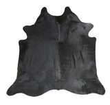 Black cowhide rug on a white background