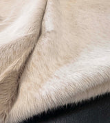 Close-up of beige cowhide on a dark background