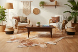 brown white cowhide rug staged in living room