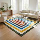 Multicolor geometric stitched cowhide rug styled beneath a glass coffee table in a bright modern living room