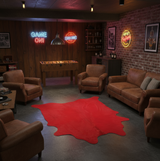 Game room with cowhide rug, neon signs, foosball table, and brown furniture.