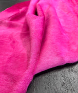 Close-up of pink cowhide on a dark surface