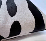 Close-up of stenciled zebra cowhide pillow showing genuine hair-on-hide texture