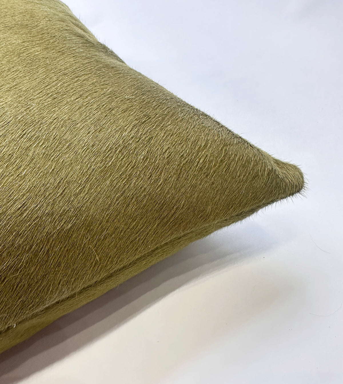 Close-up of Moss green cowhide pillow showing natural hair-on-hide texture
