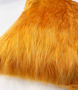 Close-up of marigold yellow cowhide pillow showing natural hair texture